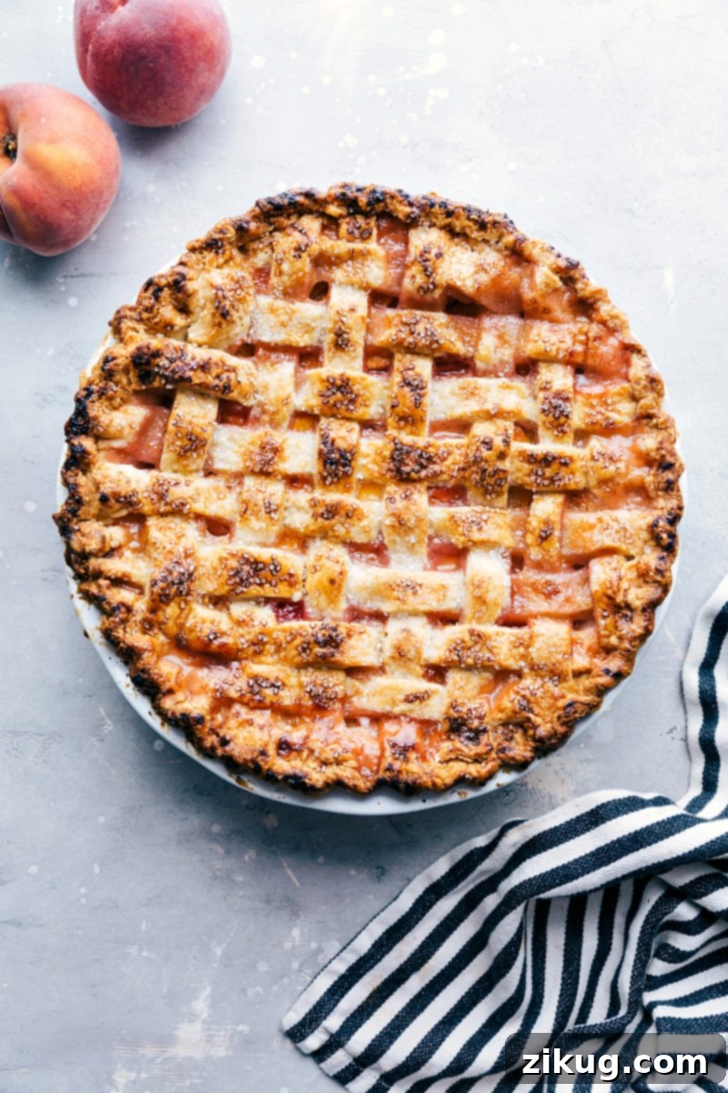 Freshly Baked Peach Pie with Sugar Topping - Accompanied by Fresh Peaches Delicious and sweet peach pie, fresh out of the oven and topped with sugar, accompanied by fresh peaches on the side.