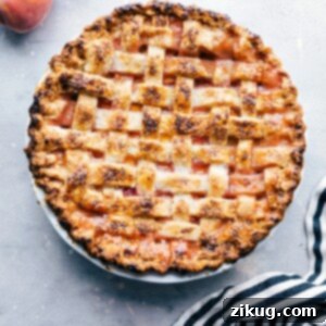 Perfectly Peachy Pie 4 Delicious and sweet peach pie, fresh out of the oven and topped with sugar, accompanied by fresh peaches on the side.