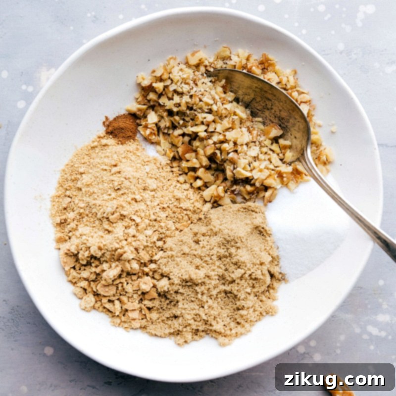 Detailed shot of preparing the crunchy walnut and graham cracker crumble topping, highlighting the rich textures and sweet ingredients before baking, perfect for a grilled pineapple sundae.