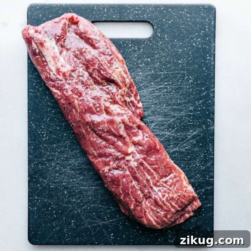 Raw meat arranged on a cutting board, prepared to be seasoned and grilled.