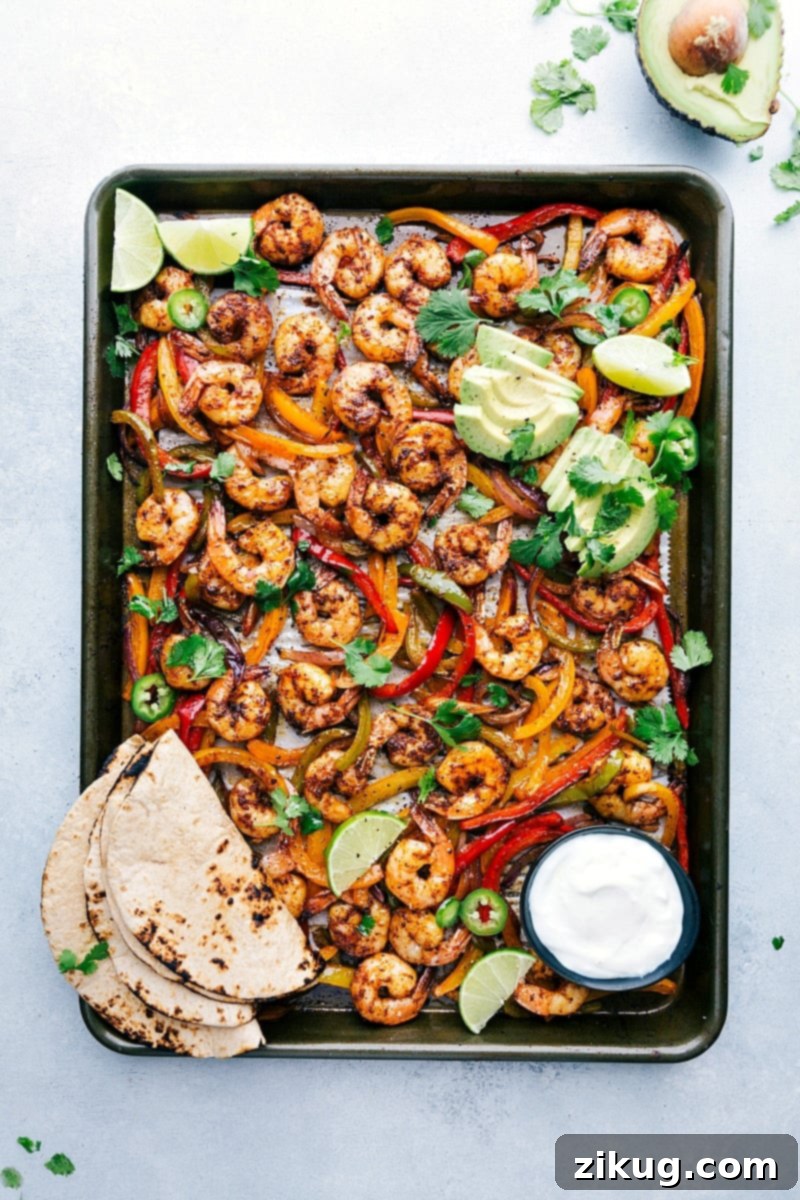 Savory Sheet Pan Shrimp Fajitas Ready to Serve Freshly baked shrimp fajitas on a sheet pan, accompanied by tortillas and a variety of toppings, all set for assembly into a mouthwatering and savory meal.