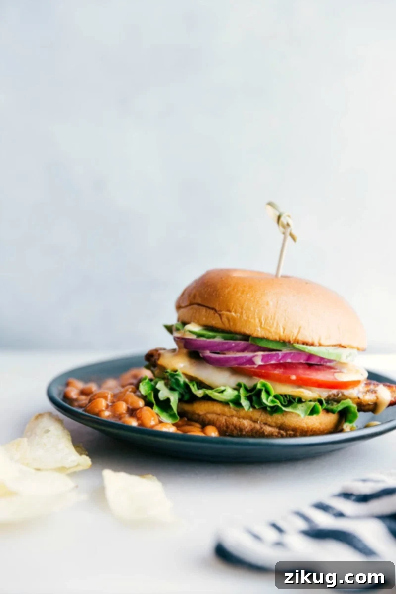 Delicious Homemade Chicken Burger with Baked Beans A chicken burger on a plate accompanied by a side of baked beans, presenting a delicious and satisfying meal, ready for enjoyment.