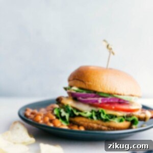Chicken Burger Meal with Baked Beans A chicken burger on a plate accompanied by a side of baked beans, presenting a delicious and satisfying meal, ready for enjoyment.