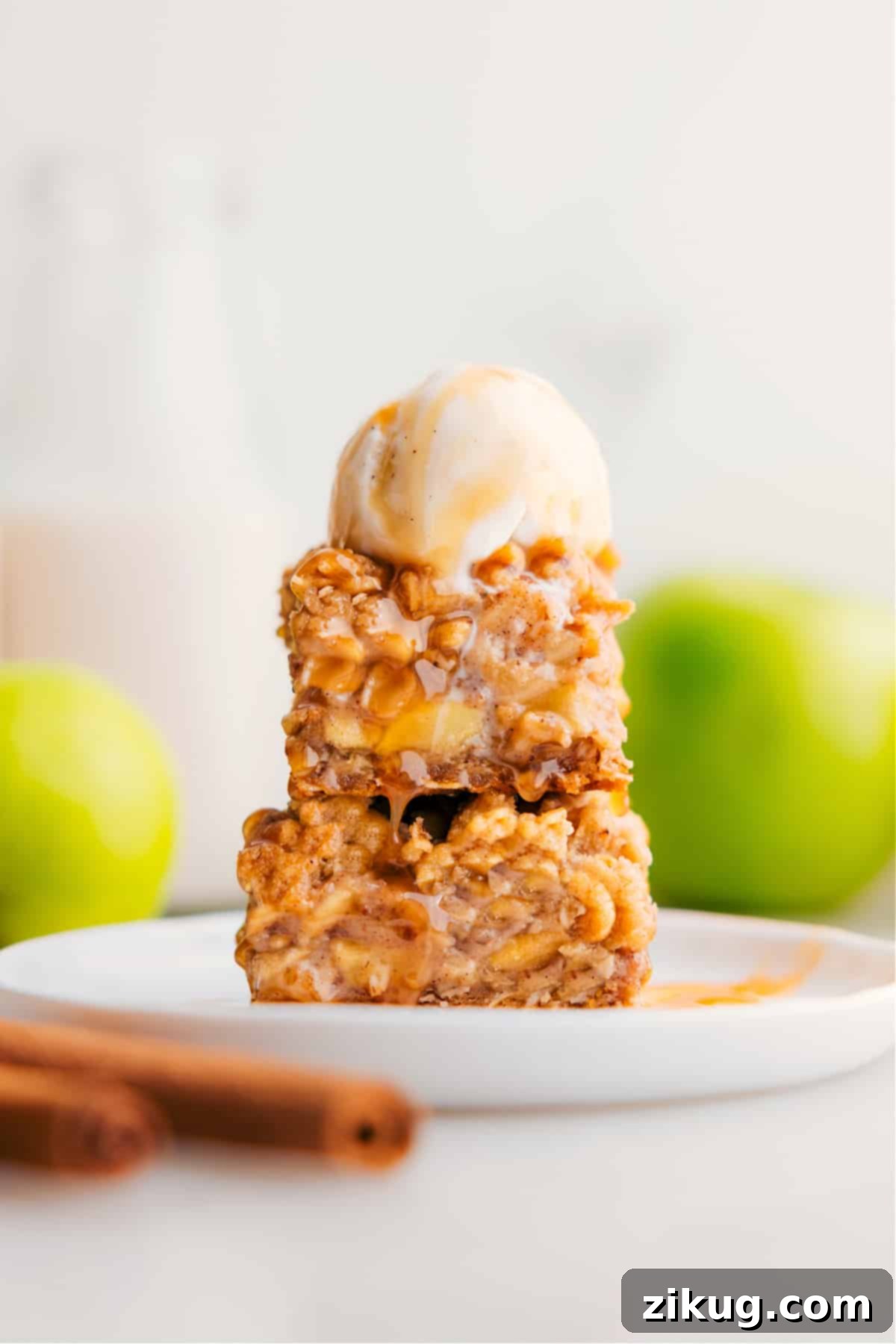 The Best Apple Pie Bars Recipe with Caramel A stack of golden brown Apple Pie Bars with a glossy caramel drizzle on top, showcasing their soft, chewy texture.