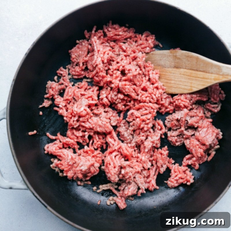 Ground beef being cooked on a skillet, a crucial step in preparing the flavorful taco filling.