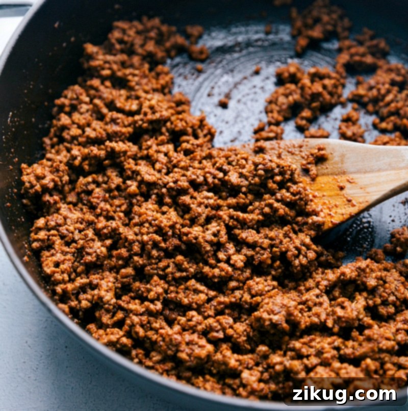 Meat being cooked in a pan with the seasoning blend, absorbing flavors until perfectly seasoned.