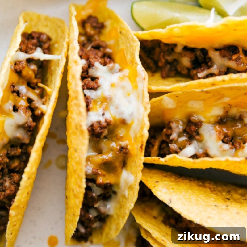 Ground beef tacos fresh out of the oven, topped with melty cheese, hot and ready to be served.