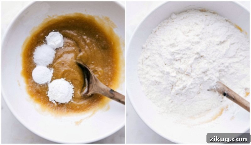 Dry ingredients, including flour, cornstarch, baking soda, baking powder, and salt, being carefully poured into the mixing bowl with the wet ingredients to form the M&M cookie dough.