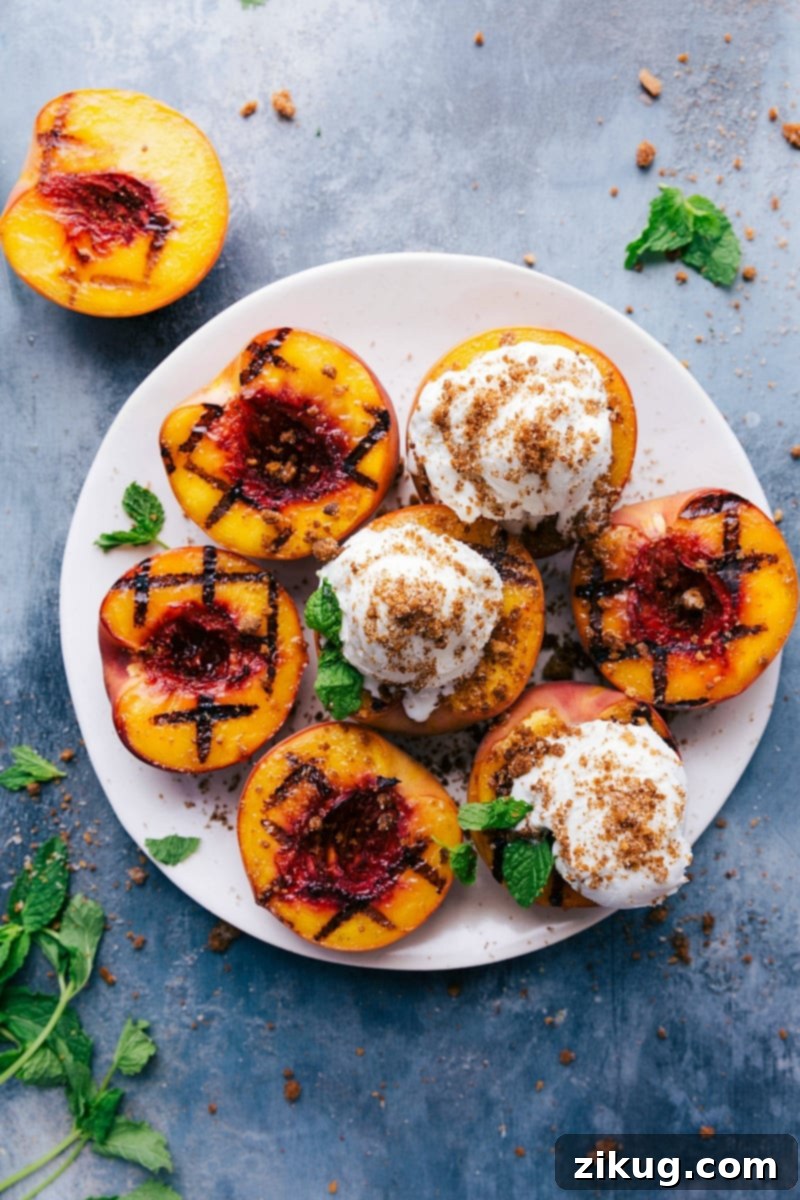 Grilled Peaches Dessert: Sweet and Fruity Delight with Ice Cream and Mint Garnish Grilled peaches with vanilla ice cream and fresh mint on top - a sweet and fruity treat, ready to be enjoyed.