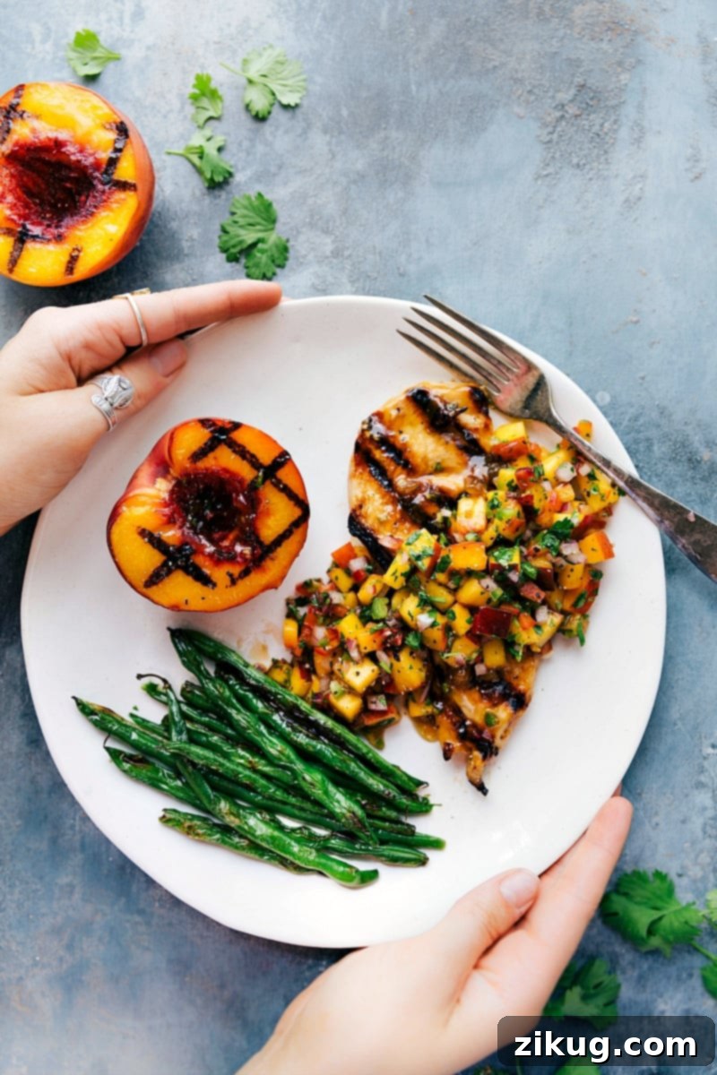 Peach Salsa Chicken with Side of Green Beans and Grilled Peach - A Flavorful Meal Peach salsa chicken served on a plate, accompanied by green beans and a freshly grilled peach on the side.