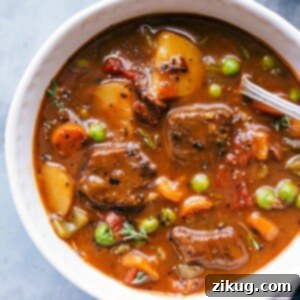 Hearty Instant Pot Beef Stew in a bowl, warm and ready to be eaten, garnished with fresh herbs.