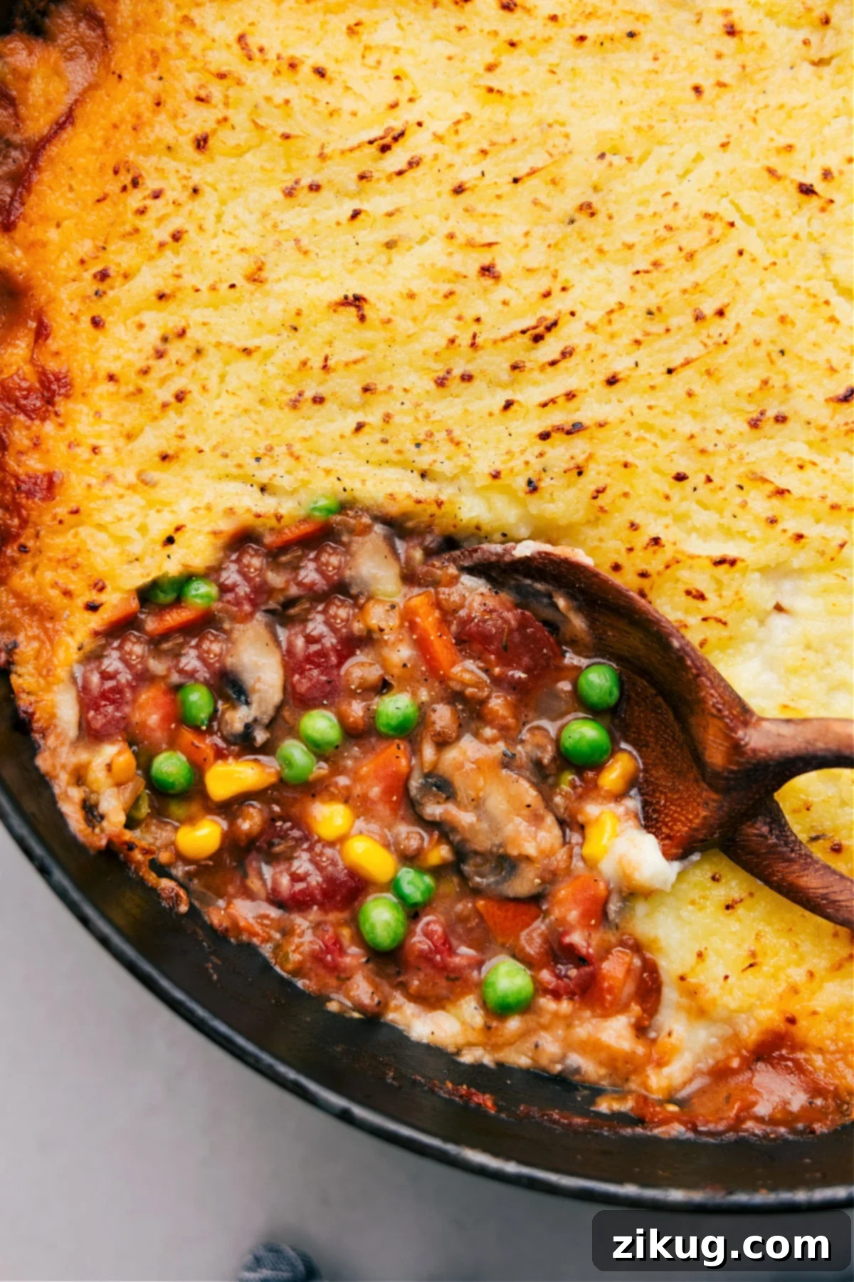 Vegetarian Shepherd's Pie on a wooden table, freshly baked and garnished with herbs.