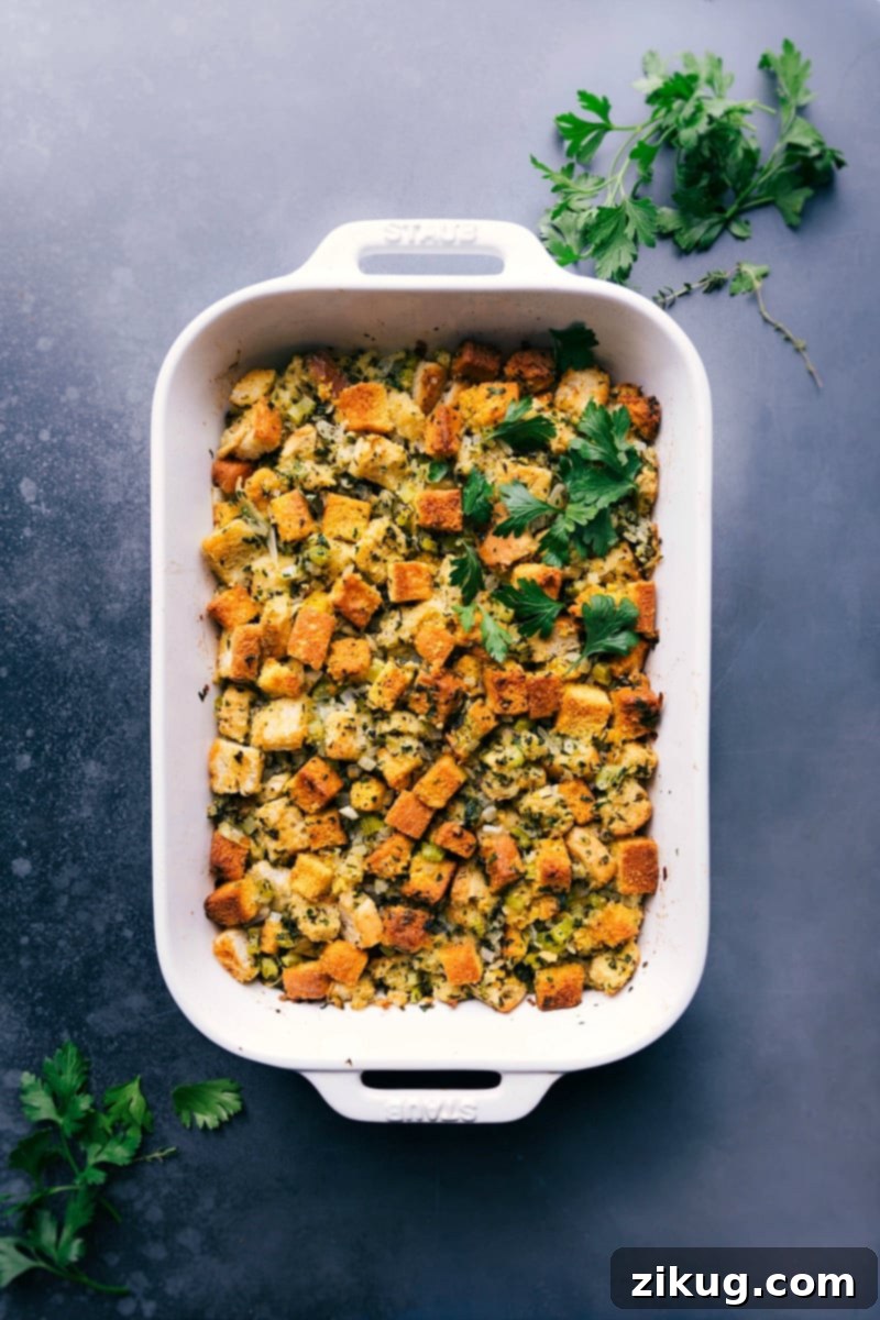 Freshly baked cornbread dressing, golden brown and garnished with vibrant fresh herbs, ready to be served at a holiday meal.