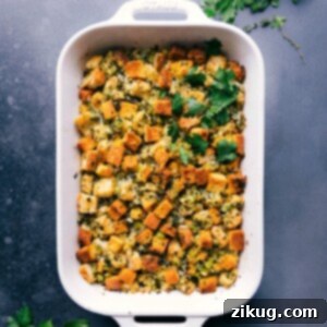 Golden brown cornbread dressing fresh out of the oven, garnished with vibrant fresh herbs.