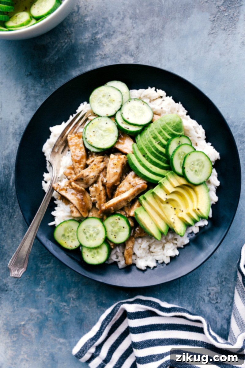 A vibrant bowl of apricot chicken with coconut rice, fresh avocado, and crisp cucumbers, forming a delicious and balanced meal.