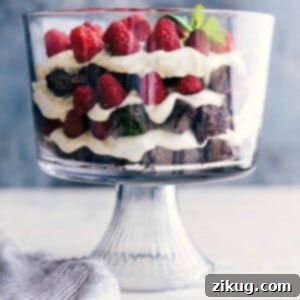 A stunning brownie trifle displaying layers of brownies, fresh fruit, and luscious cream filling, all set and inviting.