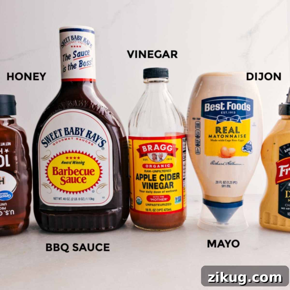 A selection of ingredients for the Crispy Chicken Salad dressing: honey, BBQ sauce, apple cider vinegar, Dijon mustard, and mayonnaise, prepped and ready for mixing.