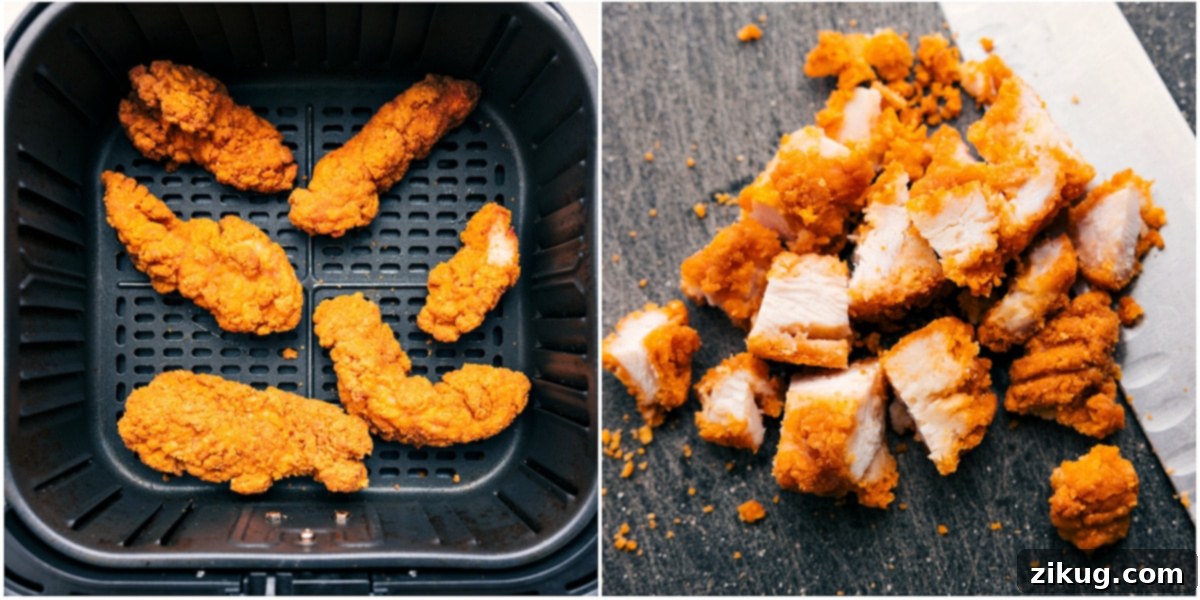 Crispy chicken tenders cooking to a golden perfection in an air fryer, ready to be added to the salad.