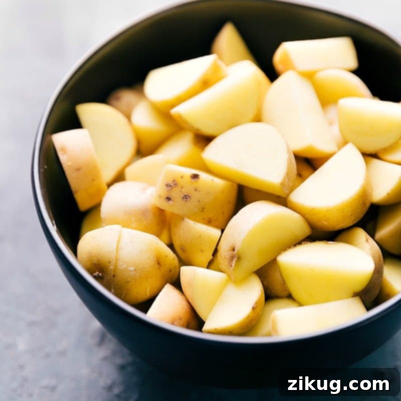 Fresh baby gold potatoes, perfectly diced and ready for cooking, showcasing their creamy texture and preparing for a flavorful curry.