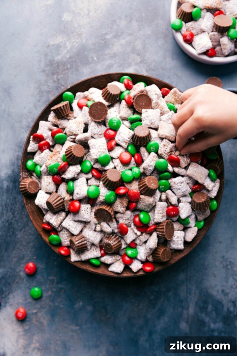 Festive Reindeer Chow with Holiday Candy Toppings Finished reindeer chow with christmas colored M&M's and reese's on top.
