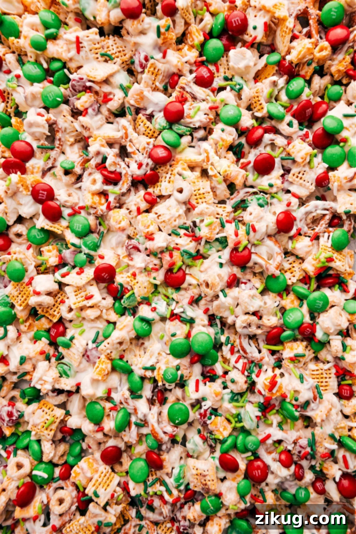 Festive Christmas Snack Mix with Green and Red M&M's and White Chocolate Coating Christmas Snack Mix with sprinkles and M&Ms on top.