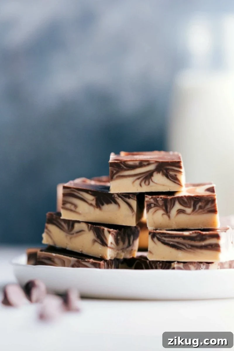 Stacked slices of Tiger Butter Fudge showcasing beautiful chocolate and peanut butter swirls, ready to be enjoyed.