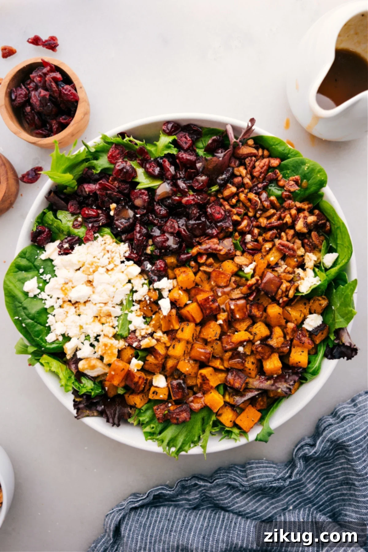 The Best Thanksgiving Salad Recipe: A Holiday Must-Have A beautifully presented Thanksgiving Salad in a large serving bowl, featuring roasted butternut squash, candied pecans, feta, dried cranberries, and mixed greens, perfectly dressed and ready to serve.