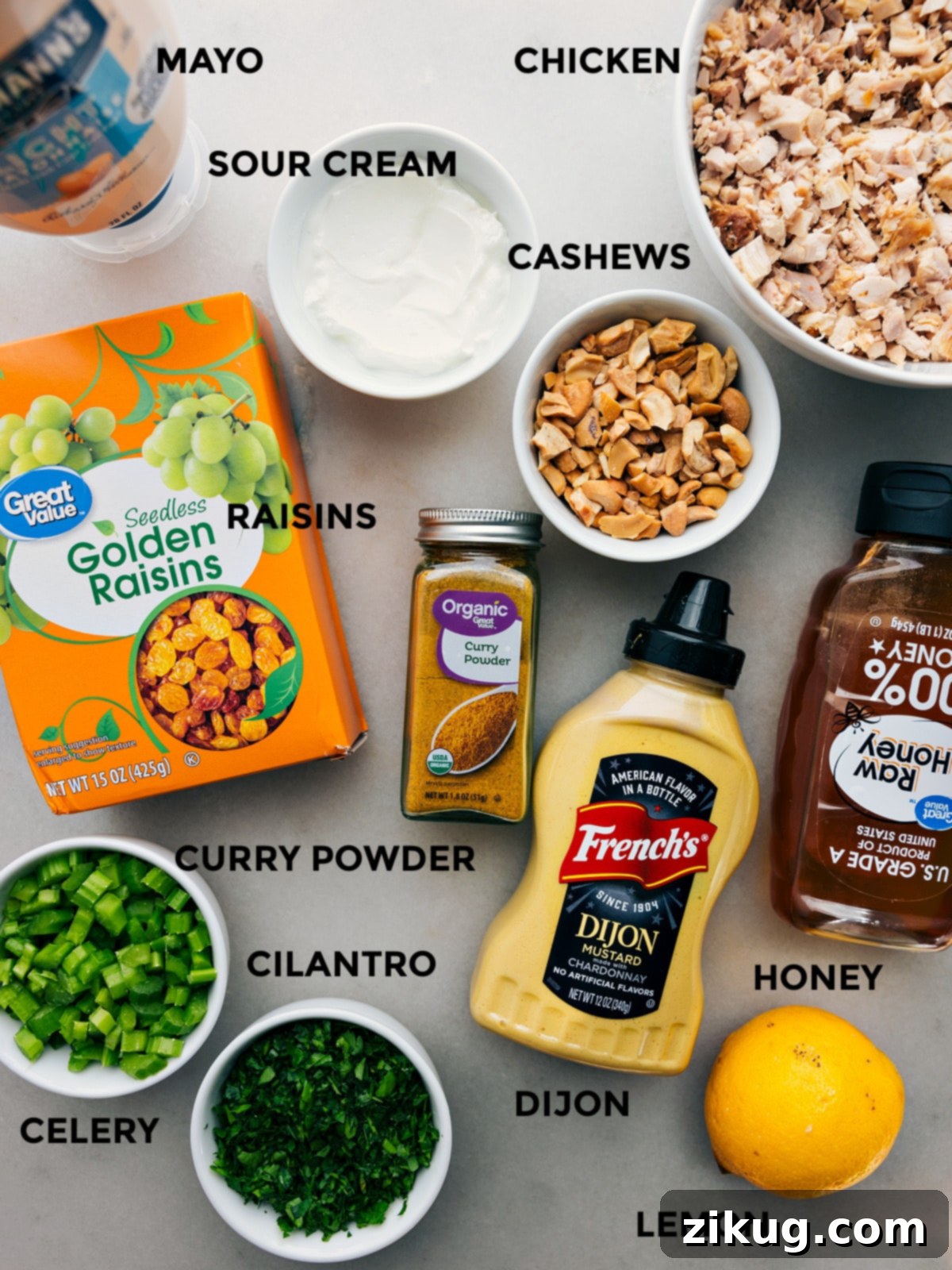 Ingredients In Curry Chicken Salad All the vibrant ingredients for Curry Chicken Salad laid out: mayonnaise, sour cream, shredded chicken, cashews, golden raisins, fresh cilantro, crisp celery, Dijon mustard, honey, and lemon.