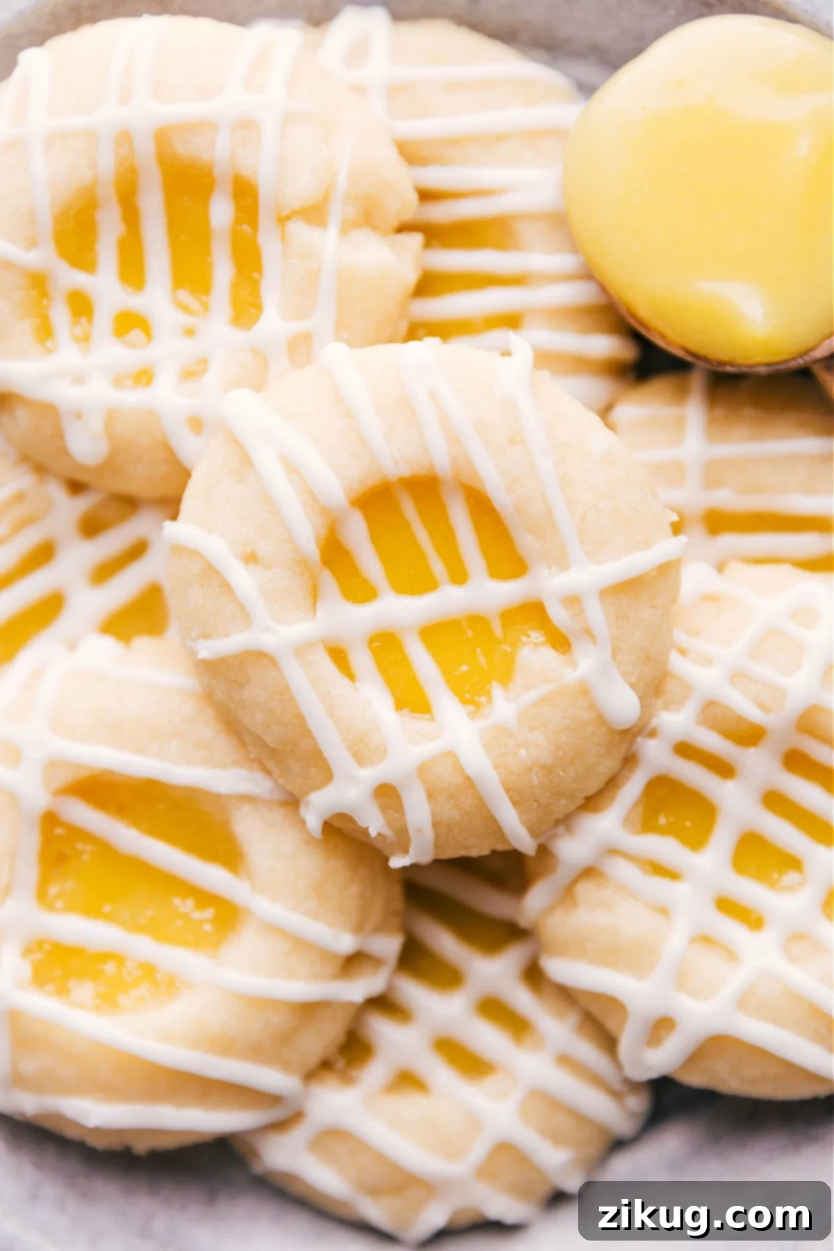 Soft, buttery cookies filled with tangy lemon curd and topped with a light glaze. A close-up shot of the perfectly baked cookies, showcasing their golden edges and vibrant yellow filling.