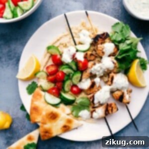 Savory Shish Tawook on skewers, perfectly arranged over a bed of smooth hummus, inviting a taste. Shish tawook skewers served atop creamy hummus, ready to eat.