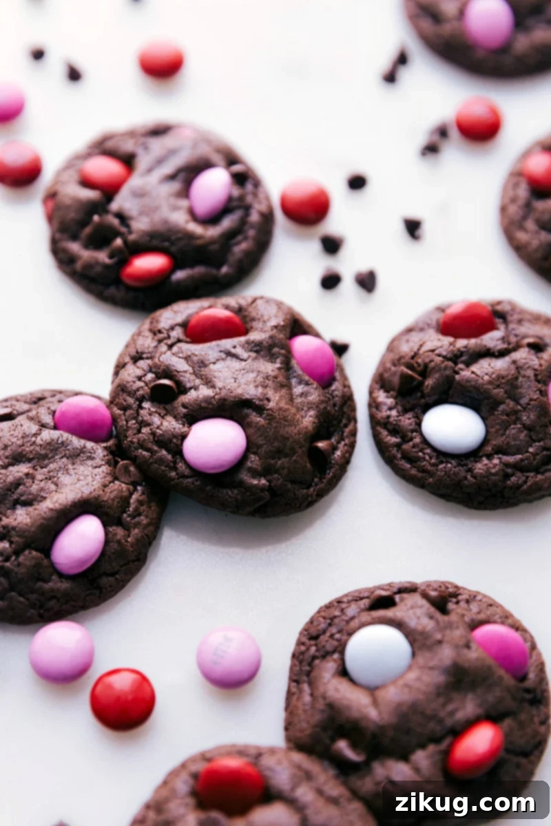 Freshly baked cookies adorned with colorful Valentine's M&M's, arranged beautifully.