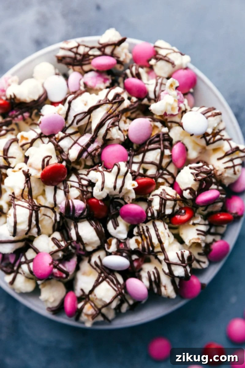 Delightful Valentine's Popcorn Ready for Consumption Bowl of delightful Valentine's popcorn, a sweet and salty treat ready to be enjoyed with chocolate, marshmallows, and colorful M&M's.