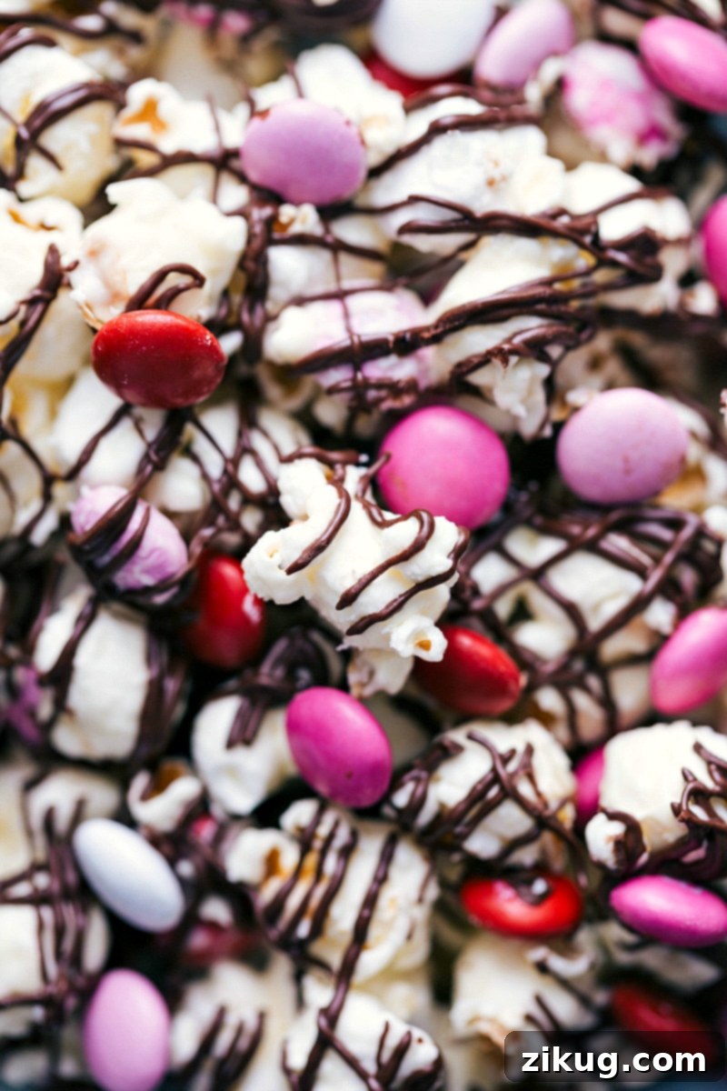 Detailed Shot of Valentine's Popcorn with Chocolate and M&M's Close-up detail of delicious Valentine's popcorn, richly coated in chocolate and adorned with colorful Valentine's M&M's and sprinkles.
