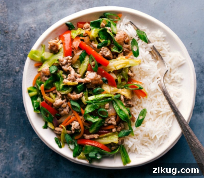 Delicious Egg Roll in a Bowl Filling Over Rice, Ready to Enjoy A hearty serving of egg roll in a bowl filling, nestled atop a bed of fluffy white rice, prepared and ready for a delicious meal.
