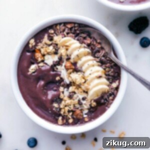 Açaí bowl with almond butter, adorned with various toppings and a spoon on the side, ready to be savored.