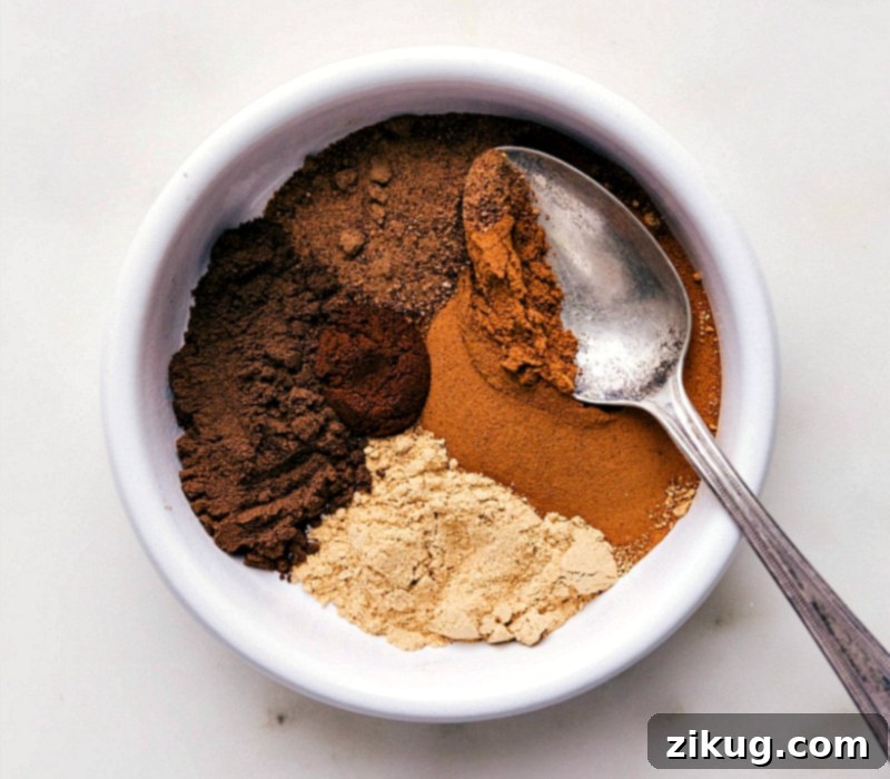 Key Ingredients for Crafting Your Own Pumpkin Pie Spice Blend An assortment of key ingredients for pumpkin pie spice recipe including ground cinnamon, nutmeg, ginger, and cloves, on a wooden surface.