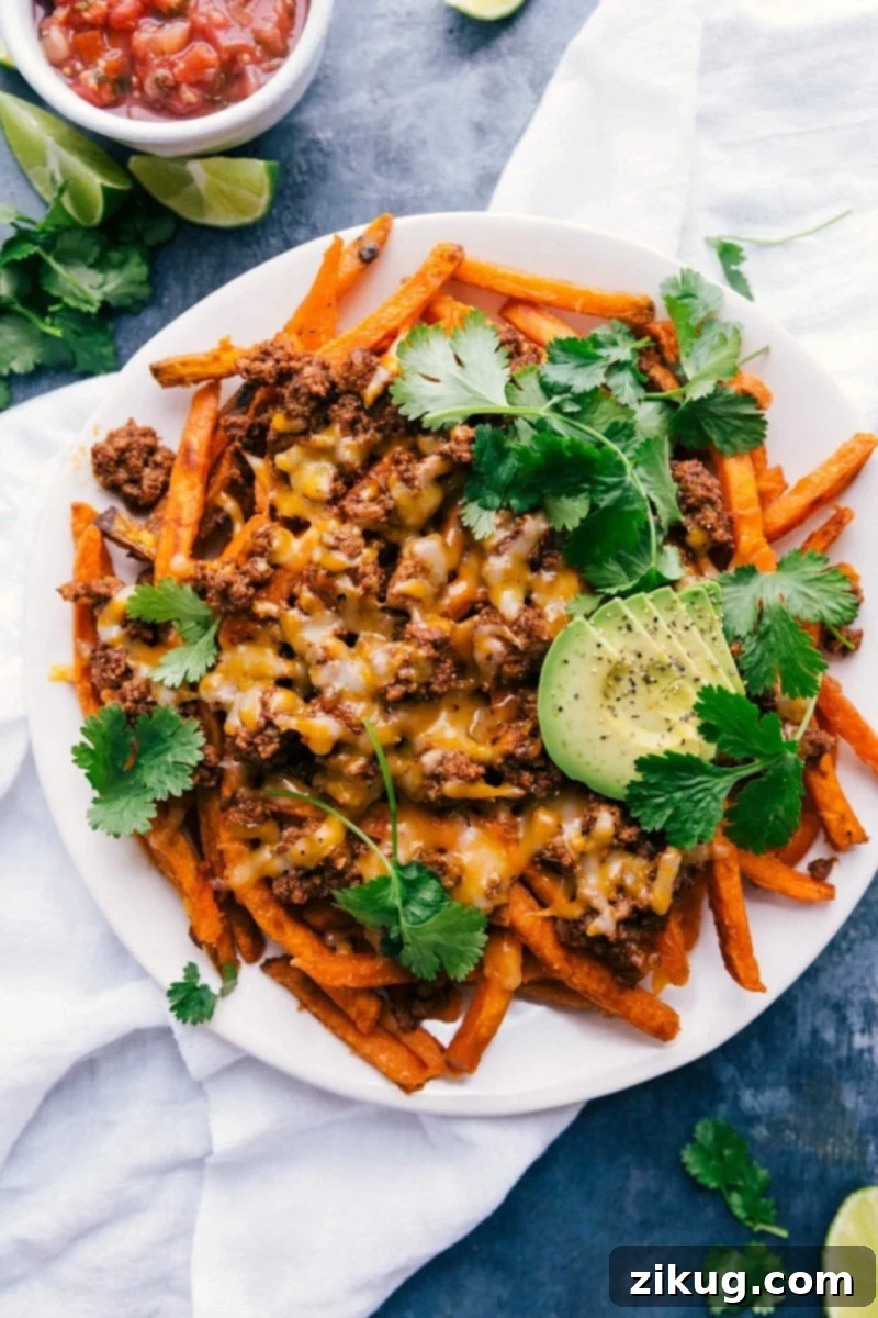 Loaded taco fries, a savory and satisfying dish with melted cheese and fresh toppings like avocado, cilantro, and sour cream.