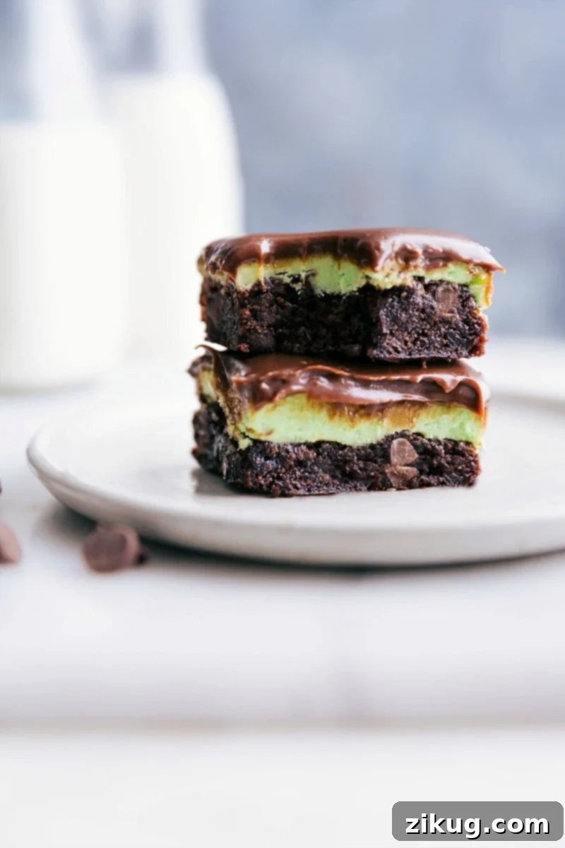 Stacked squares of mint brownies with a bite taken out of the top one.