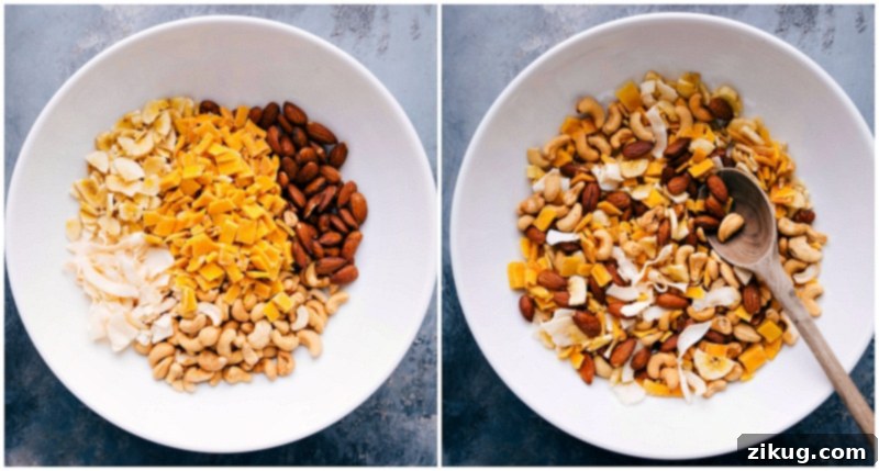 Assorted tropical trail mix ingredients, such as crunchy banana chips, coconut flakes, dried mango, and various nuts, being combined in a bowl.