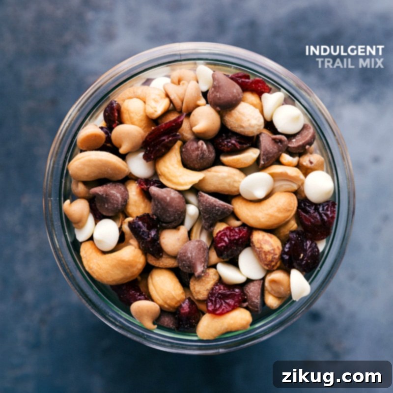A glass jar filled with the finished, ready-to-eat indulgent snack, featuring a delightful blend of nuts, dried fruits, and various chocolate morsels.