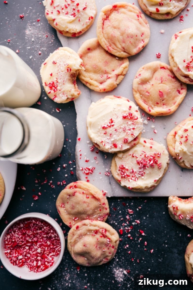 Festive Peppermint Sugar Cookies 7 A festive platter of Peppermint Sugar Cookies, frosted and garnished with crushed candy canes, ready to be enjoyed.