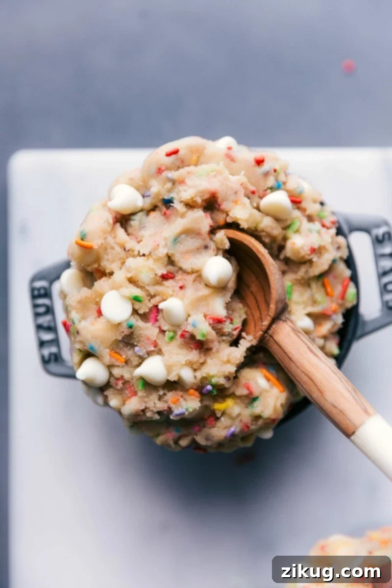Scrumptious edible cake batter in a bowl, complete with a spoon, ready for indulgence.