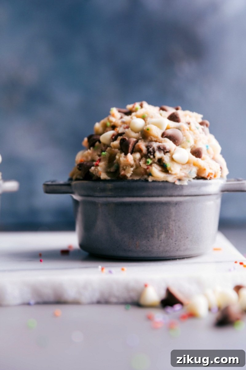 Creamy edible cake batter dough in a bowl, enriched with white and milk chocolate chips and colorful sprinkles.