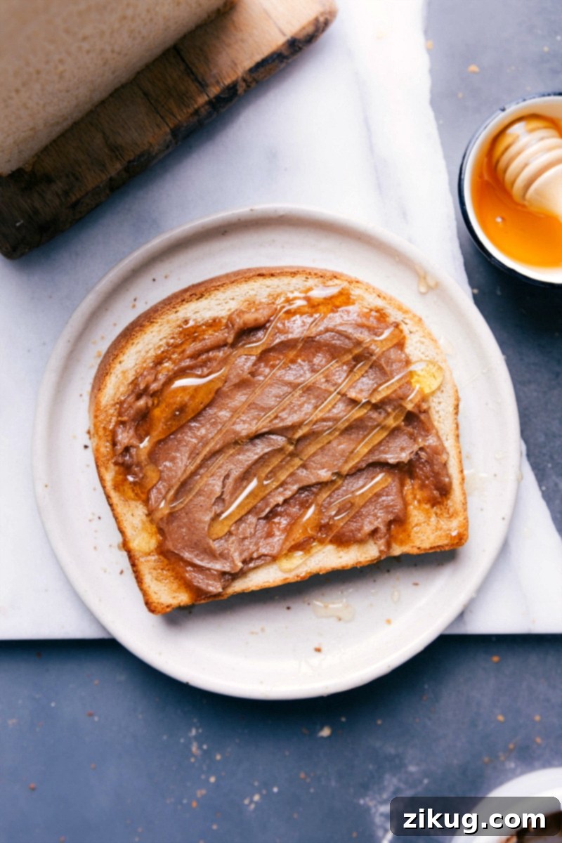 Indulgent Slice: Fresh Bread with Honey and Creamy Honey Butter A slice of bread topped with fresh honey and a dollop of honey butter.