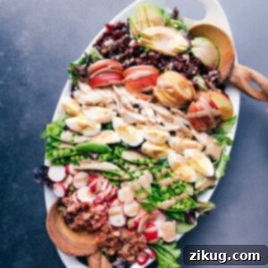 Spring Cobb Salad with Creamy Balsamic Dressing 2 A generous serving platter heaped with a cobb salad masterpiece, boasting meats, fresh vegetables, fruit, and drizzled with creamy balsamic dressing.