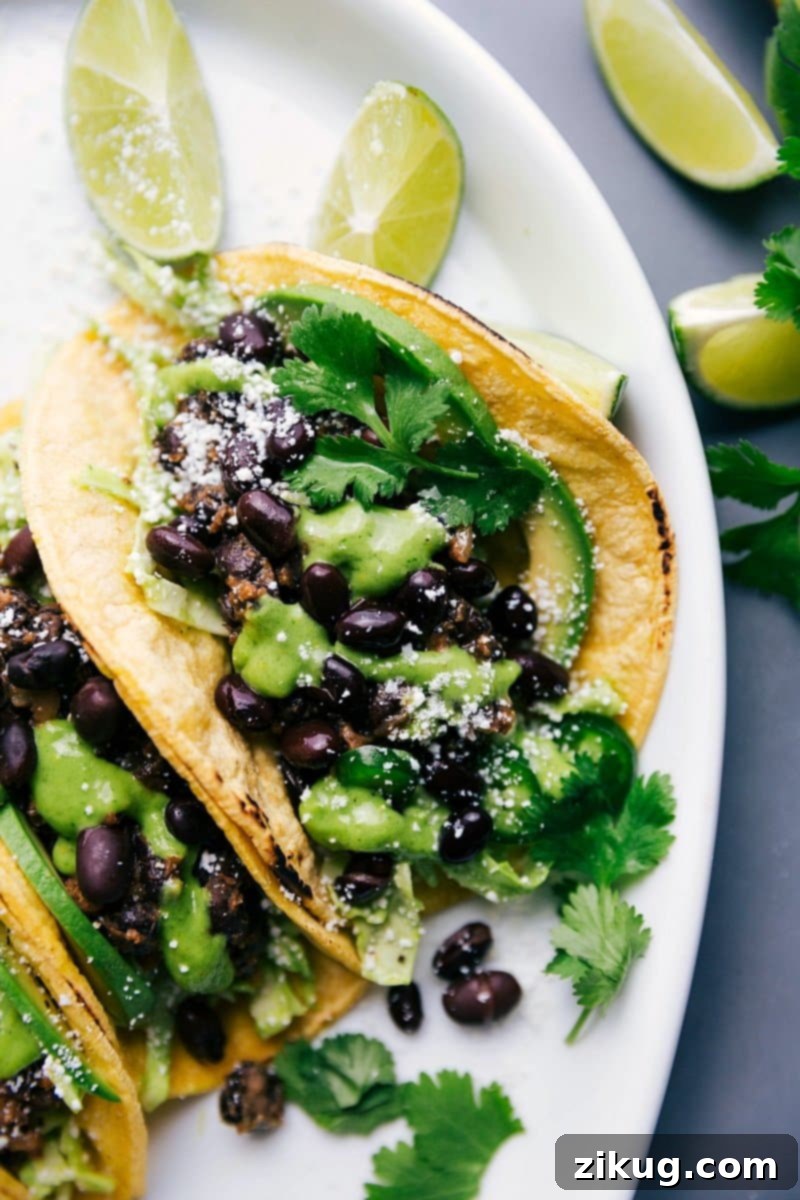Tasty Black Bean Tacos Drizzled with Homemade Cilantro Sauce and Fresh Limes on the Side, Ready to Savor. Vibrant Black Bean Tacos with a generous drizzle of homemade cilantro sauce, garnished with fresh cilantro and lime wedges, perfectly arranged and ready to be enjoyed.