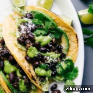 Zesty Black Bean Tacos 2 Black bean tacos with cilantro sauce and limes, ready to eat.
