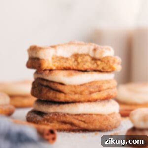 A plate of Cinnamon Roll Cookies topped with swirls of cream cheese frosting and a sprinkle of cinnamon sugar.