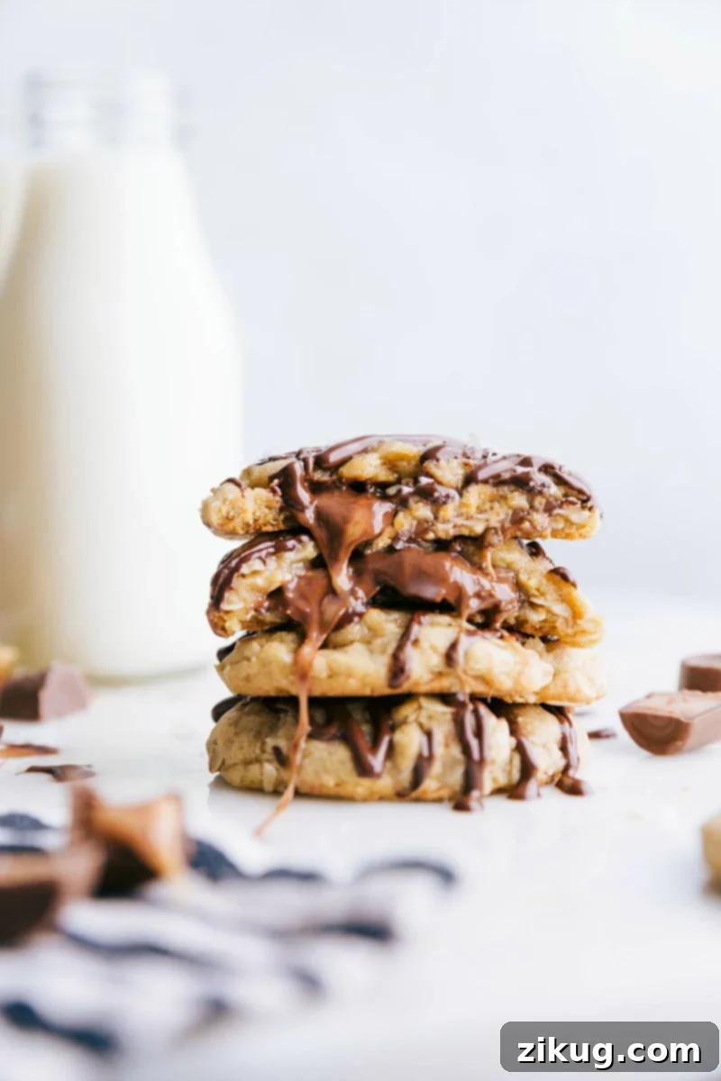 Caramel Oatmeal Cookies with Gooey Center Ready-to-eat caramel oatmeal cookies stacked on top of each other, with one broken in half to reveal the gooey caramel center.