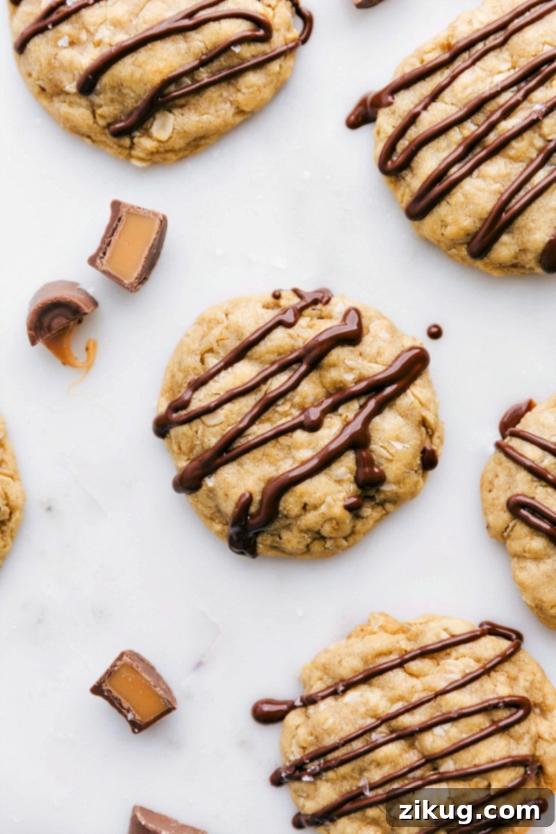Salted Caramel Oatmeal Cookies with Chocolate Drizzle Baked, ready-to-eat salted caramel oatmeal cookies with a drizzle of chocolate on top, showcasing their delicious and indulgent appearance.